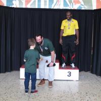 Matthieu reçoit la médaille d'or des mains d'Émile.  Ricardo médaille de bronze.